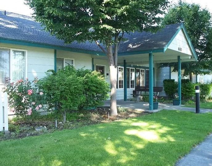 a house with a porch and a tree in front of it
